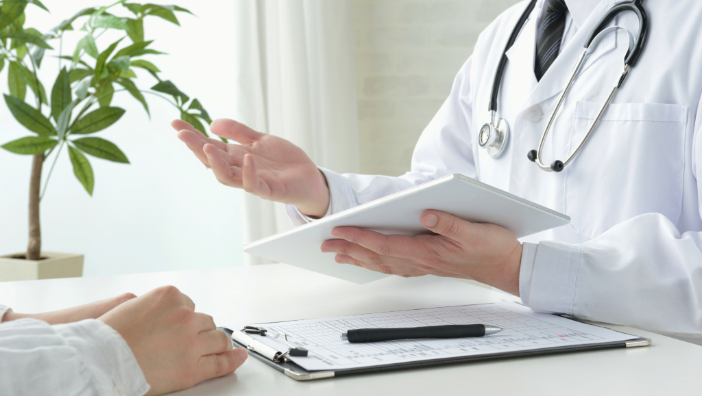 A doctor engages in conversation with a patient, discussing health concerns in a clinical setting.
