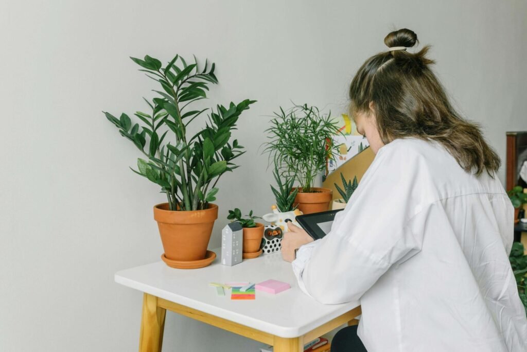 A serene home study space with a laptop, herbal textbooks, and botanical illustrations, showing someone learning natural health online in a warm, welcoming UK-style environment.